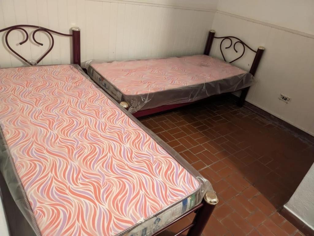 two beds sitting next to each other in a room at Depto la falda Cordoba in La Falda