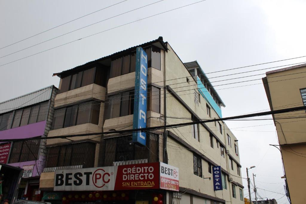 um edifício alto com sinais ao lado em JULIUS Hostal -NO PARQUEO, Alojamiento desde las 14 horas hasta 12 mediodía- em Quito