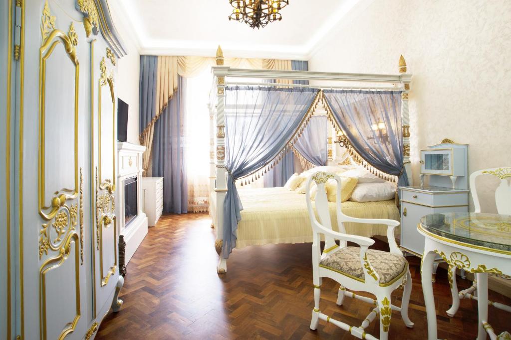 1 dormitorio con cama con dosel, mesa y sillas en Art Apartments Celakovskeho Sady, en Praga