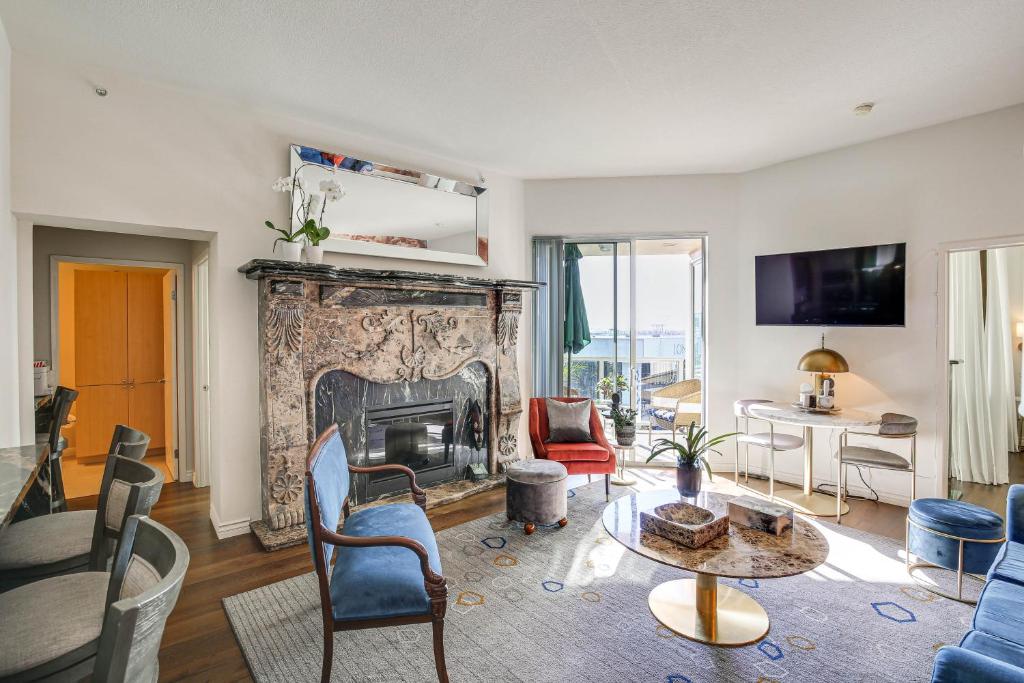 a living room with a fireplace and a table at Luxe Long Beach Condo with Pool 1 Mi to Shoreline! in Long Beach