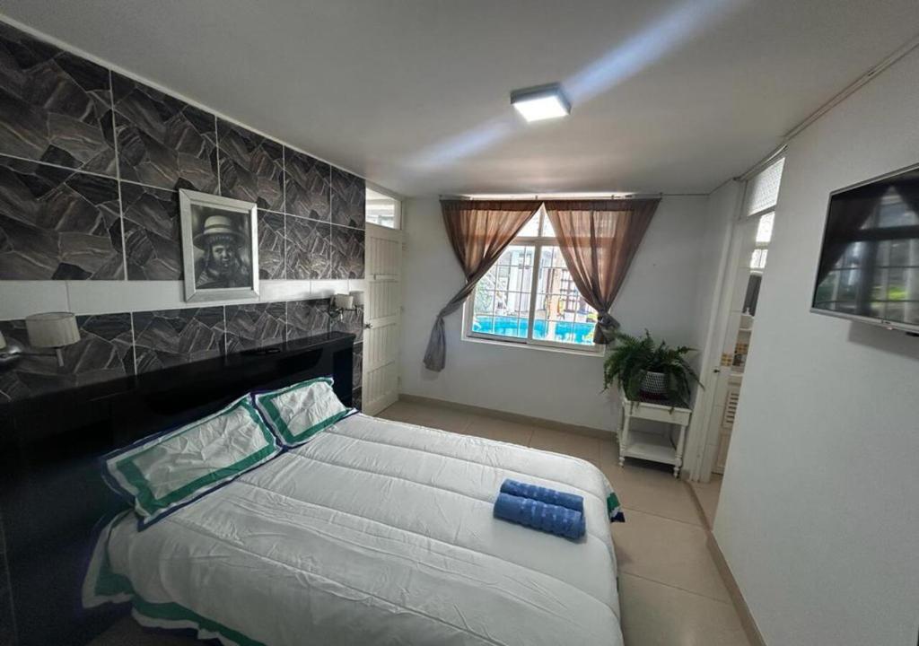 1 dormitorio con 1 cama grande y chimenea en Apartamento Playa Arica, en Lurín