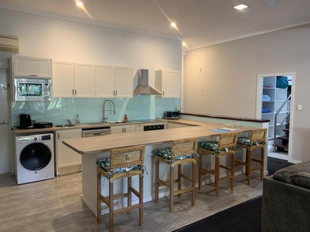a kitchen with a large island with bar stools at The Residence at MobyDick Resort in Yamba