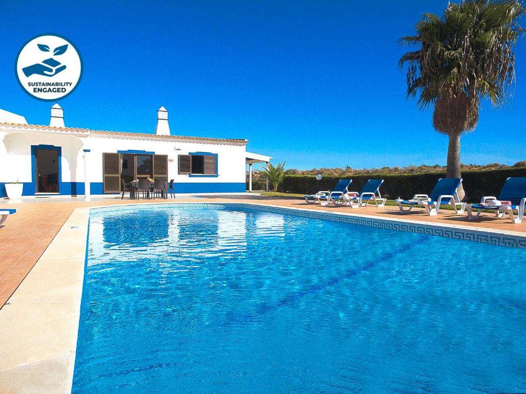 a swimming pool in front of a house at Villa Sardenha by Algarve Vacation in Guia