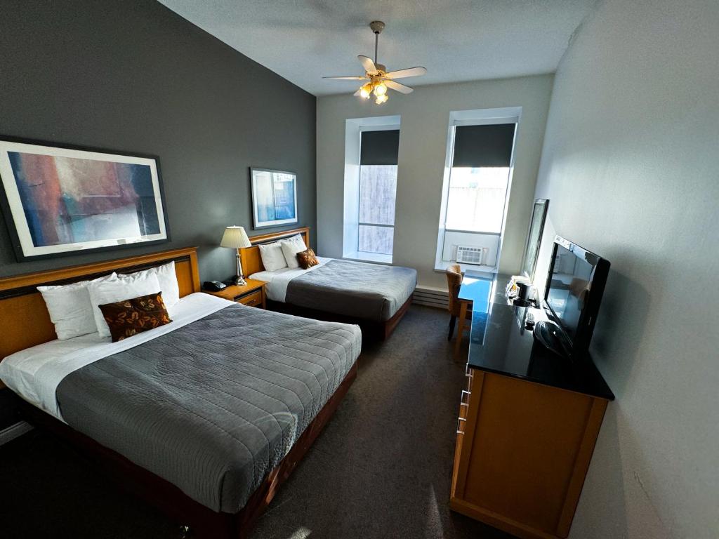 a hotel room with a bed and a flat screen tv at The Met Hotel in New Westminster