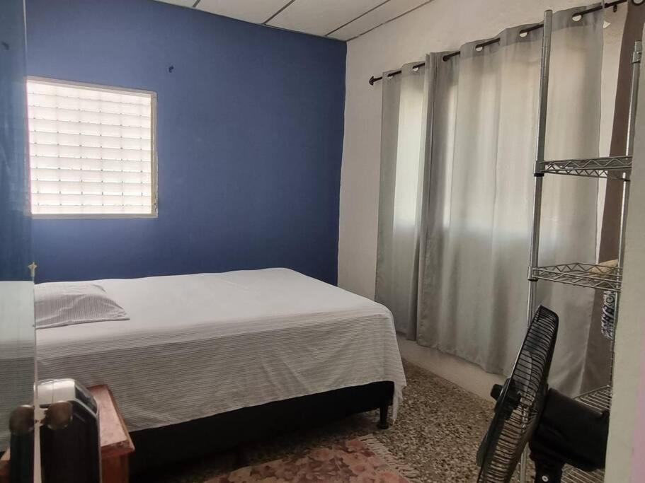 um quarto com uma cama e uma parede azul em Casa La Ermita em San Benito