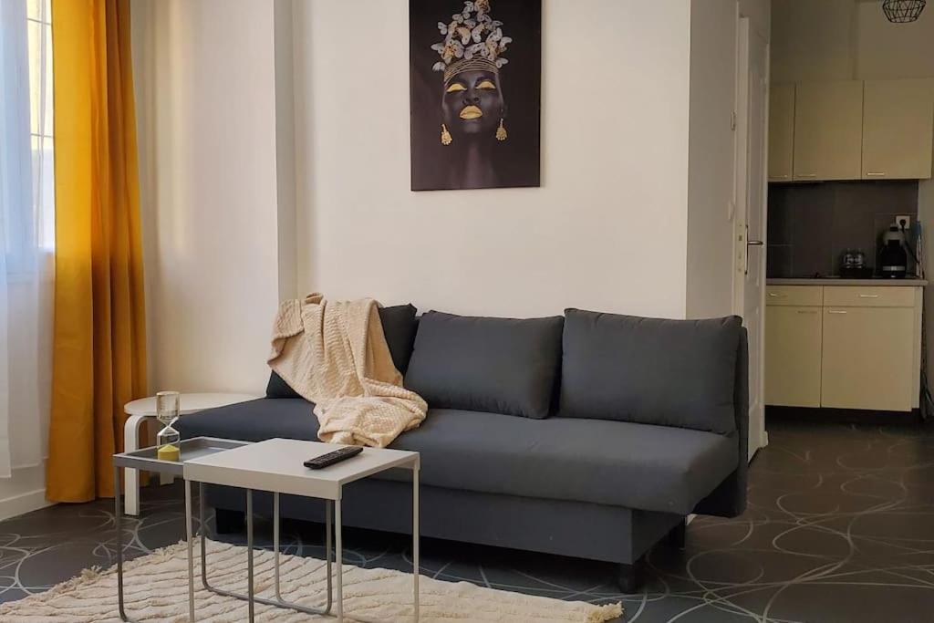 ein Wohnzimmer mit einem blauen Sofa und einem Tisch in der Unterkunft Tulsa Home - Cosy et calme in Saint-Quentin