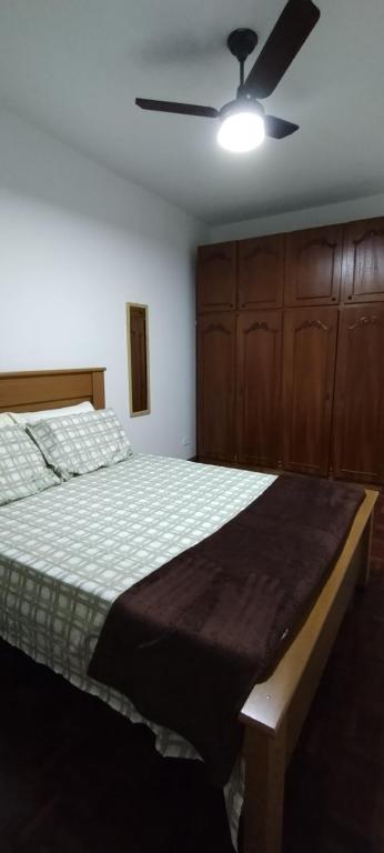 1 dormitorio con 1 cama y ventilador de techo en Apartamento Guarapari, en Guarapari