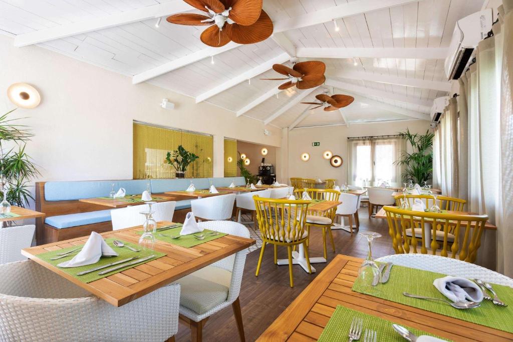 a restaurant with wooden tables and white chairs at Alua Suites Fuerteventura - All Inclusive in Corralejo