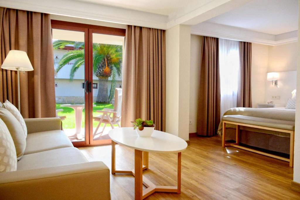 a hotel room with a bed and a table at Alua Suites Fuerteventura - All Inclusive in Corralejo
