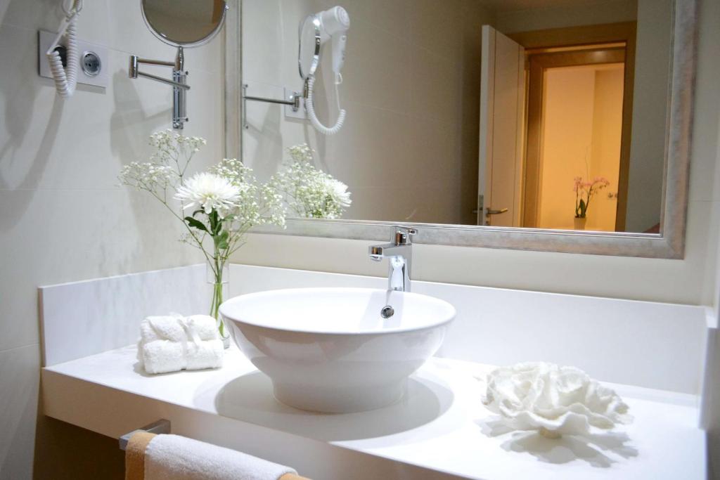 a bathroom with a white sink and a mirror at Alua Suites Fuerteventura - All Inclusive in Corralejo