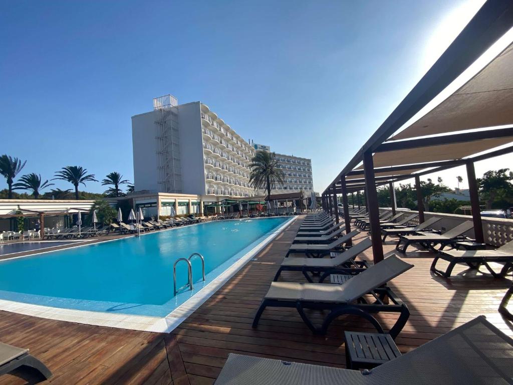 una piscina con tumbonas y un hotel en Alua Illa de Menorca en S'Algar