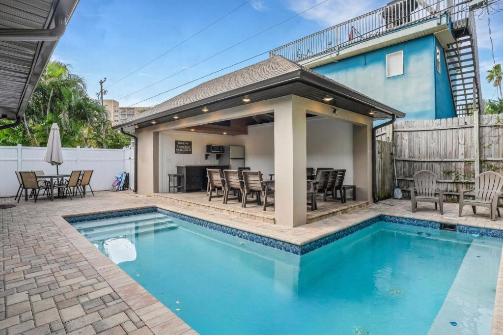 una piscina con patio y una casa en Island Time - Weekly Beach Rental home, en Clearwater Beach