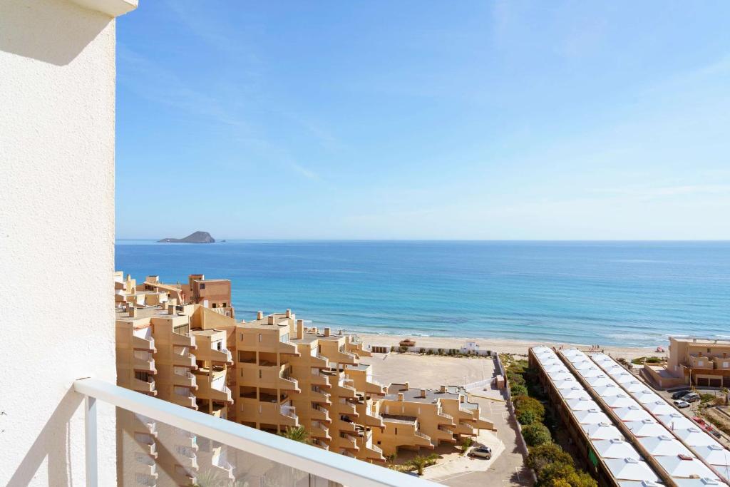 Una vista del océano desde el balcón de un edificio. en AluaSun Doblemar, en La Manga del Mar Menor