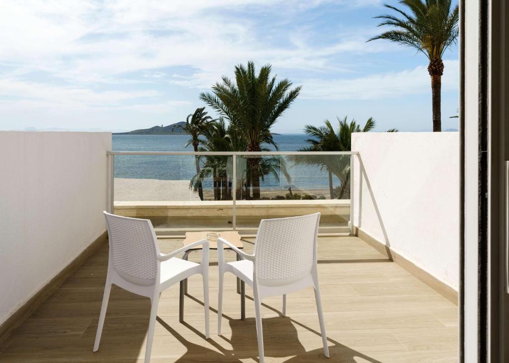 un balcón con 2 sillas, una mesa y el océano en AluaSun Doblemar, en La Manga del Mar Menor