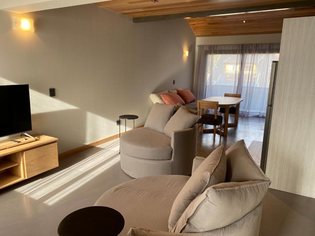 un salon avec deux canapés et une télévision dans l'établissement Departamento Andina, à San Martín de los Andes