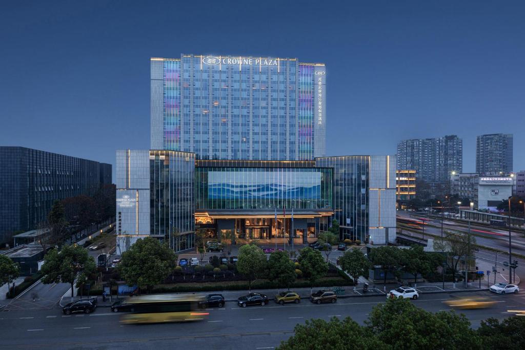 成都的住宿－成都武侯渝江皇冠假日酒店，一座大型玻璃建筑,在城市里装有汽车