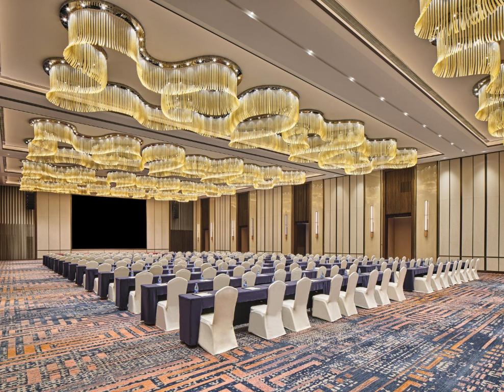 成都市にあるCrowne Plaza Chengdu Wuhou by IHGの椅子とシャンデリアが備わる空の会議室