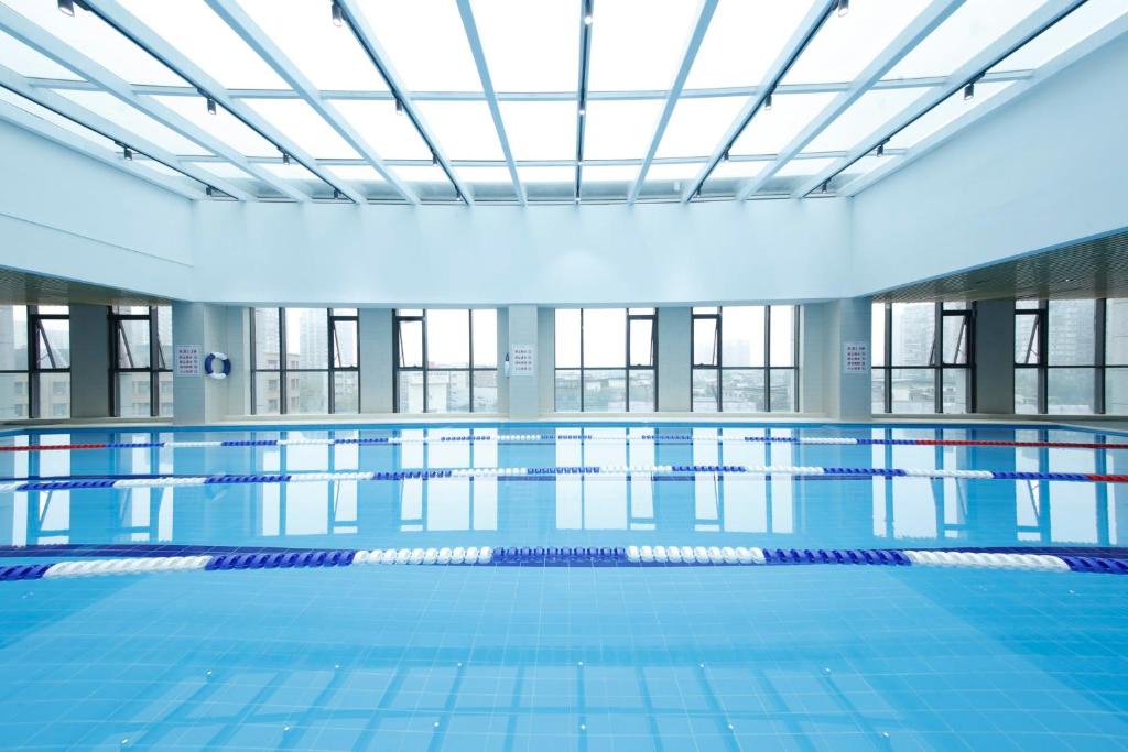成都市にあるCrowne Plaza Chengdu Wuhou by IHGの建物内の青いタイルが敷かれた大きなプール