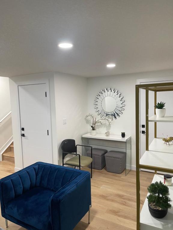 a living room with a blue couch and a mirror at Stylish 2 Bedroom suite in SW Edmonton close to Windermere and Edmonton International Airport in Edmonton