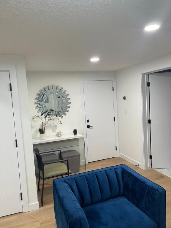a living room with a blue couch and a table at Stylish 2 Bedroom suite in SW Edmonton close to Windermere and Edmonton International Airport in Edmonton