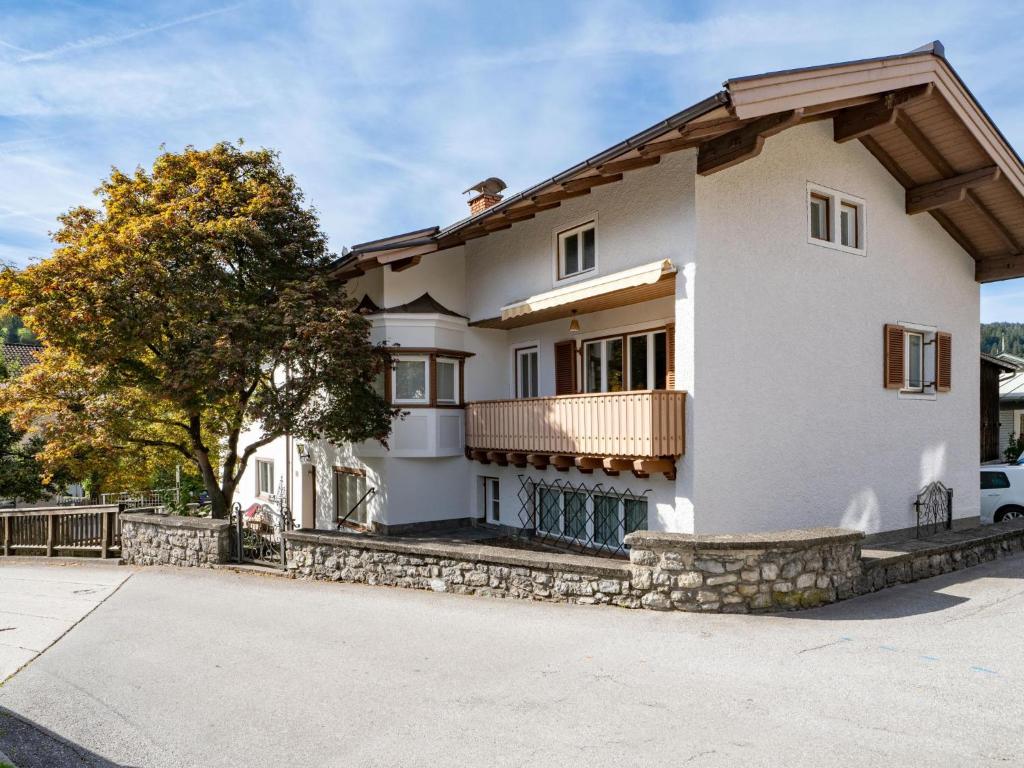 Une grande maison blanche avec balcon est située dans une rue. dans l'établissement Föchlhaus am Marktgraben, à Hopfgarten im Brixental