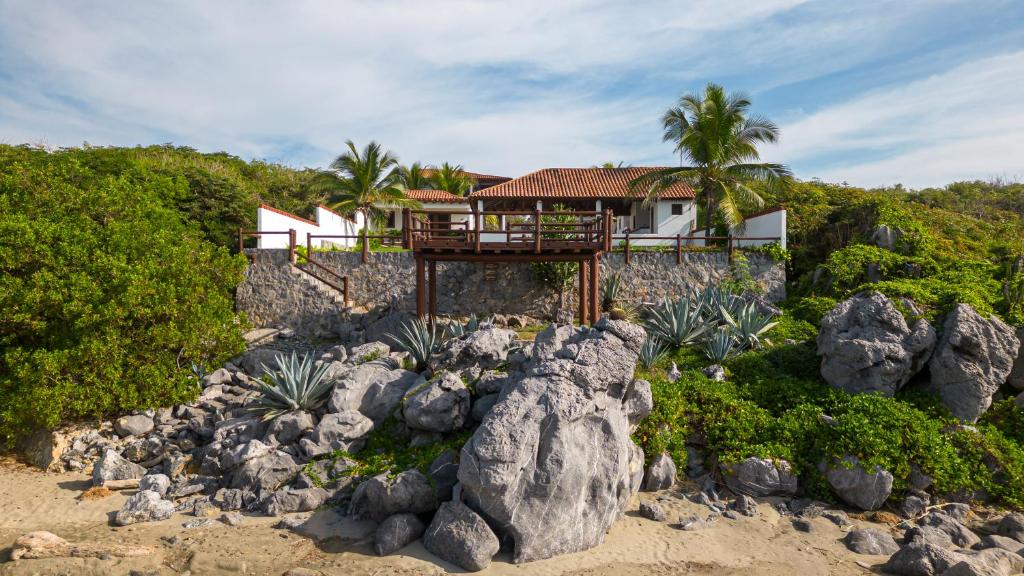 a house on the beach next to some rocks at Refugio de piedra - Troncones in Troncones