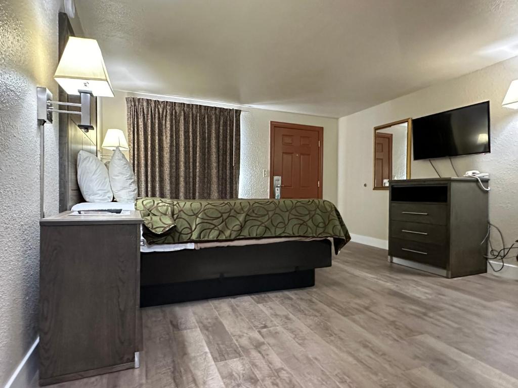 a hotel room with a bed and a flat screen tv at Motel In The Pines in Munds Park
