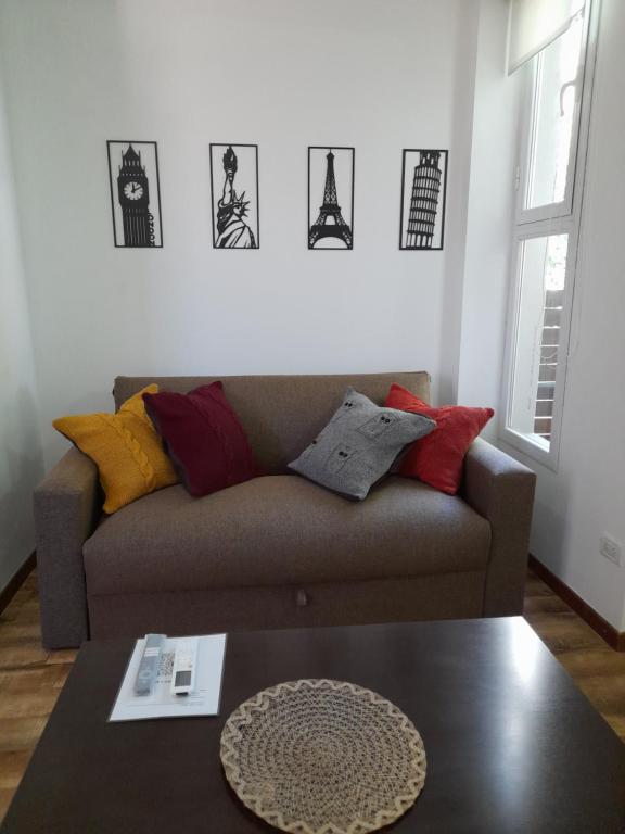 una sala de estar con sofá y algunas fotos en la pared en Departamento Paso en Mar del Plata