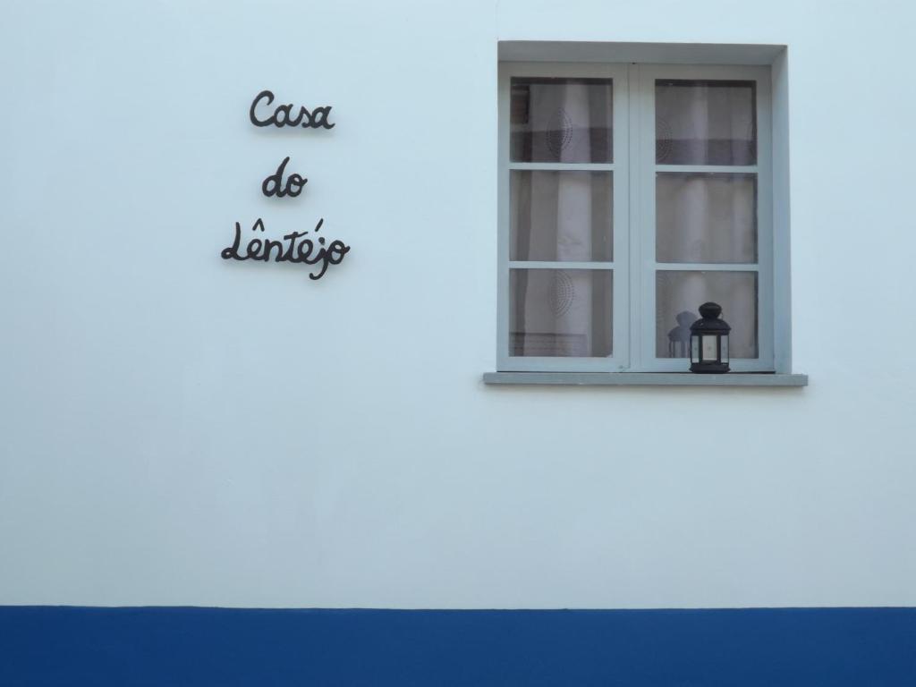 een raam op een wit gebouw met een bord waarop staat dat de klas de was doet bij Casa do Lêntejo - Casas de Taipa in São Pedro do Corval