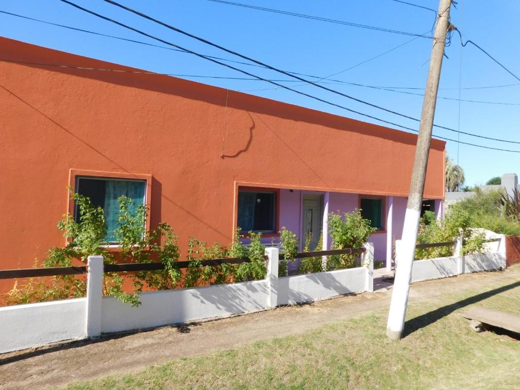a orange building with plants in the windows at ARCO IRIS in La Coronilla