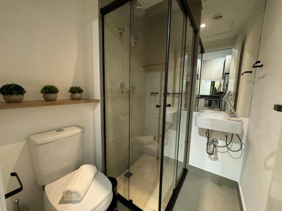 a bathroom with a shower and a toilet and a sink at Jardins São Paulo in Sao Paulo