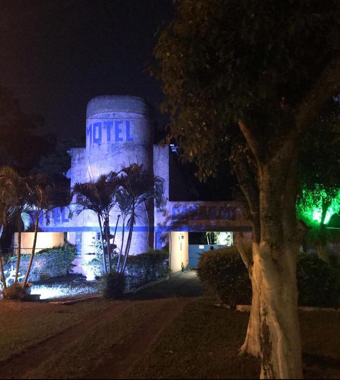 um edifício com luzes azuis à noite em Motel Casarão em Osório