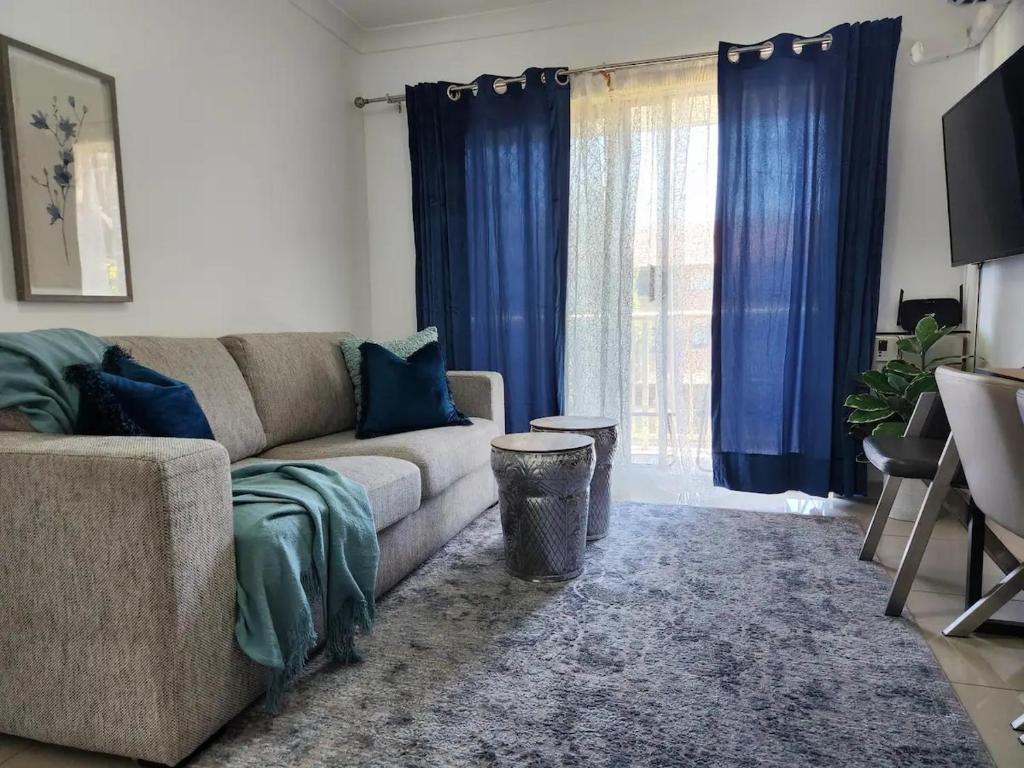 a living room with a couch and blue curtains at Chic Boutique 2BR Apt Walk to Station w/ Parking in Sydney