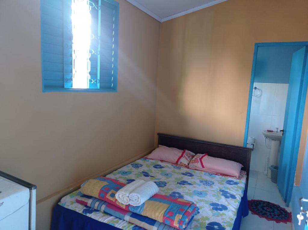 アウト・パライーゾ・デ・ゴイアスにあるQuarto privativo com banheiroのベッドと鏡のある小さな寝室