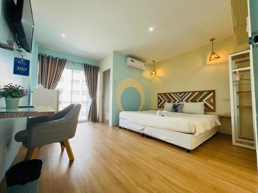 a bedroom with a bed and a desk and a chair at Castaway's 420 in Hua Hin