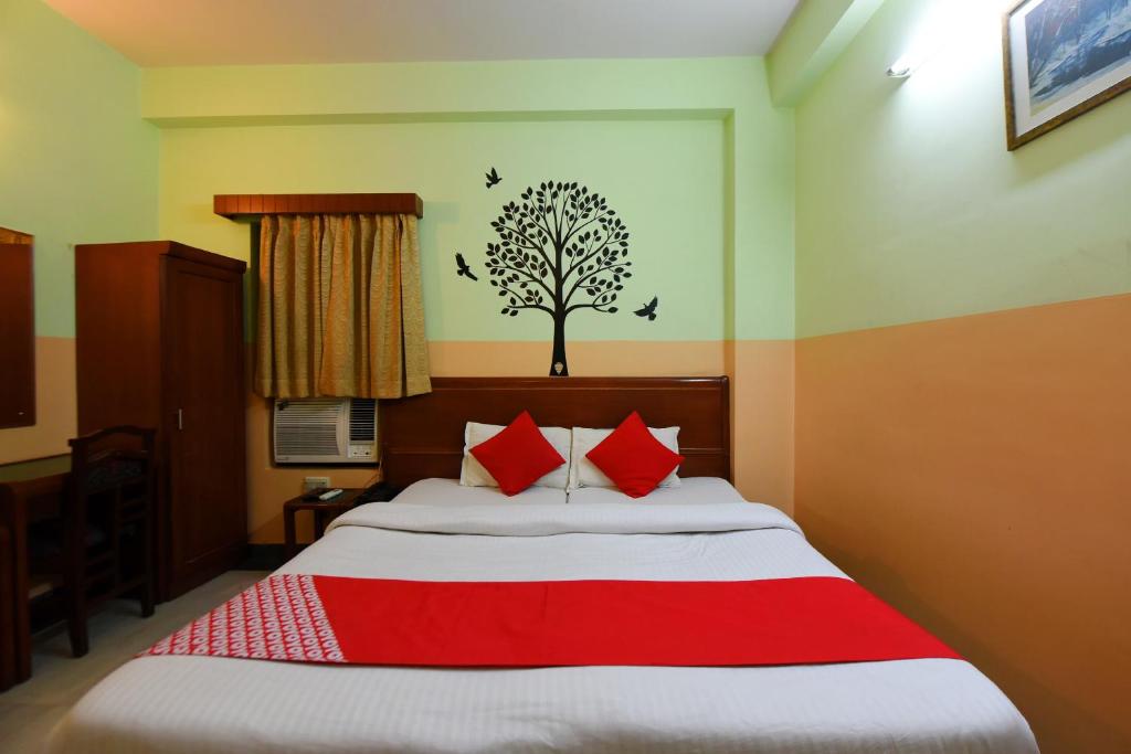 a bedroom with a bed with a tree on the wall at Collection O Hotel Blue Bird in Jaipur