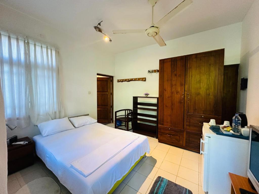 a bedroom with a white bed and a television at Haus Berlin in Negombo