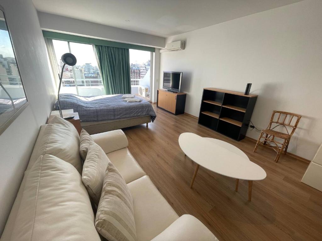 a living room with a couch and a bed at Studio Apartment on 13th Floor Above 9 de Julio Avenue in Buenos Aires