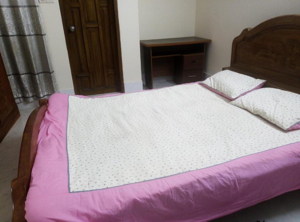 a bedroom with a bed with purple sheets and a table at Rent Room in Bashundhara R A near US Embassy in Dhaka