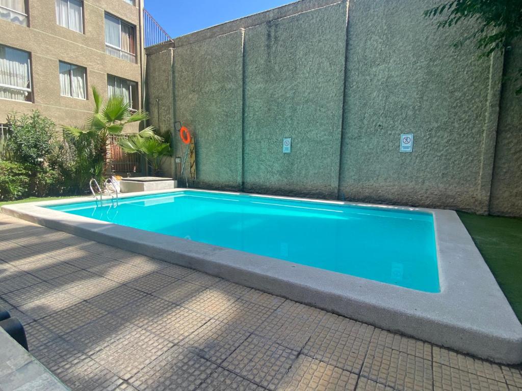 uma piscina azul em frente a um edifício em Apartamento completo amoblado Santiago cercano Movistar Arenas em Santiago
