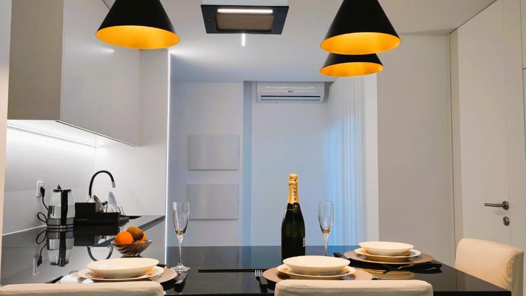 una cocina con una mesa con dos copas y una botella de vino en A1.0 - Alexa Smart house, en Braga