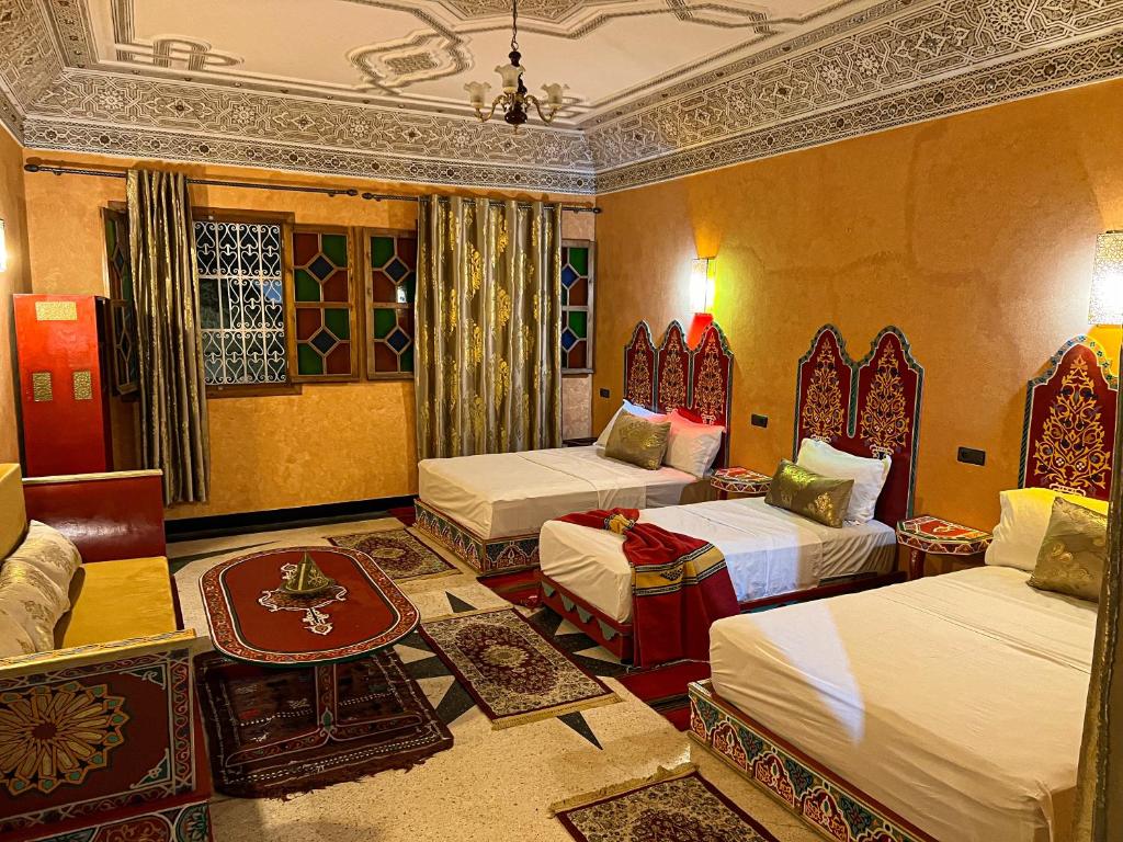a hotel room with two beds and a table at Riad Dar Doura in Rabat