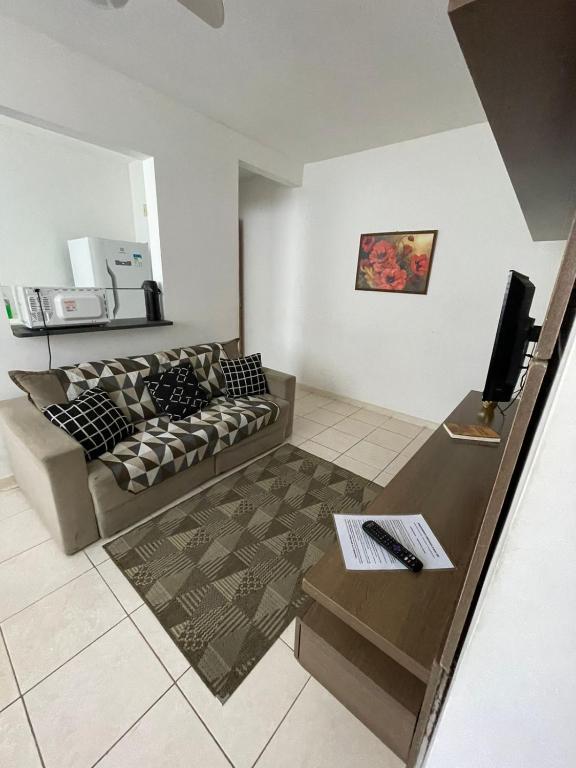 a living room with a couch and a table at Onix Sol e Piscina in Campos dos Goytacazes