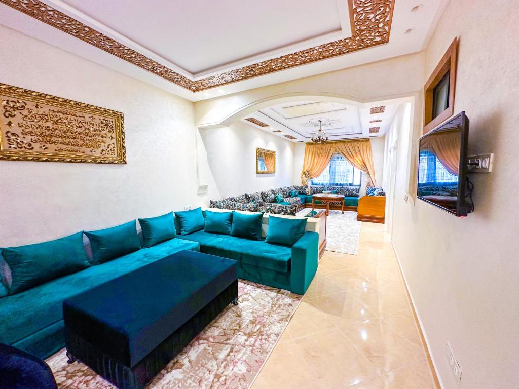 a living room with a blue couch and a tv at Luxury of Mesnana in Tangier