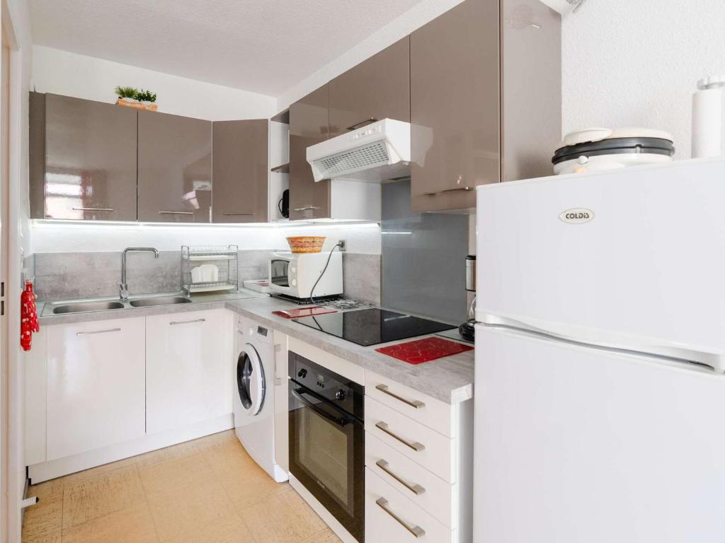 Il comprend une cuisine équipée d'appareils électroménagers blancs et d'un réfrigérateur blanc. dans l'établissement Appartement T2 avec loggia, 4 couchages, proche plage et commerces, Narbonne-Plage - FR-1-409-128, à Narbonne