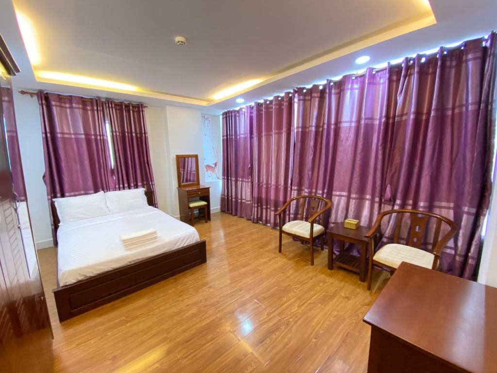 Schlafzimmer mit einem Bett, einem Tisch und Stühlen in der Unterkunft FriendZoneS Hotel in Ấp Bình Hưng