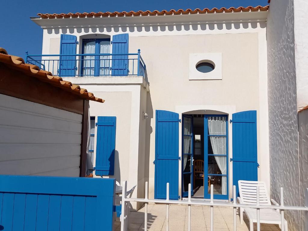 Maison bleue et blanche avec portes bleues dans l'établissement Maison de Vacances Idéale: Proche Mer, Golf et Thalasso, Jardin Privatif, 6 Pers, Parking Inclus - FR-1-323-364, à Saint-Jean-de-Monts