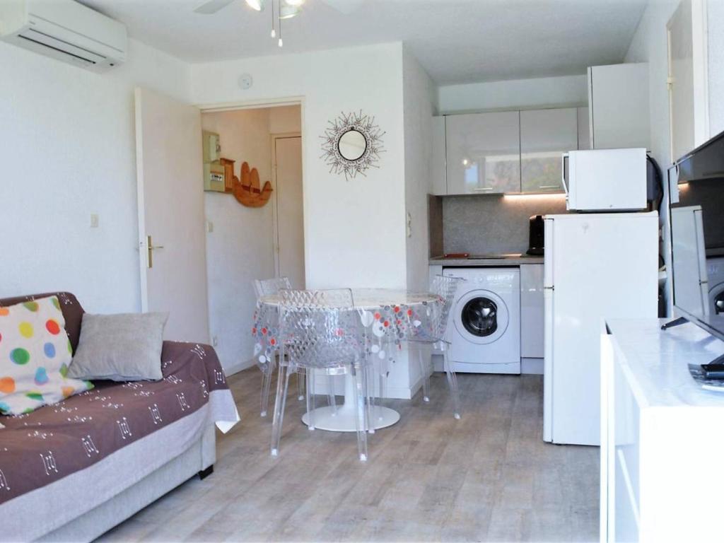 un salon avec un canapé et une table dans une cuisine dans l'établissement Appartement Bormes-les-Mimosas, 2 pièces, 4 personnes - FR-1-251-571, à Bormes-les-Mimosas