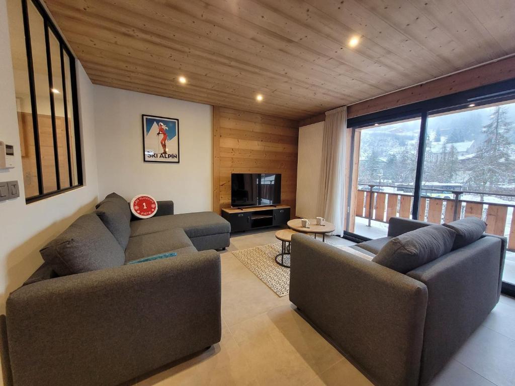un salon avec deux canapés et une télévision dans l'établissement Appartement rénové, lumineux et calme, au centre des Gets, proche pistes et commodités - FR-1-598-158, aux Gets