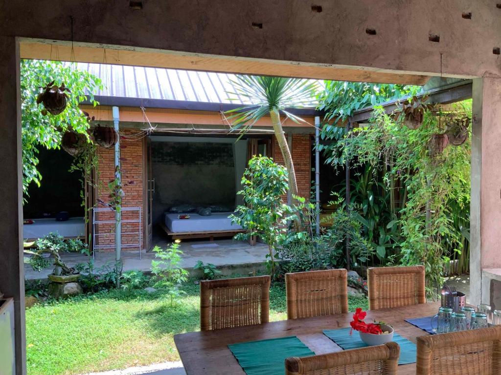a patio with a table and chairs in a yard at Villa di Bukit Lawang: LocalDailyLife, near Jungle in Bukit Lawang